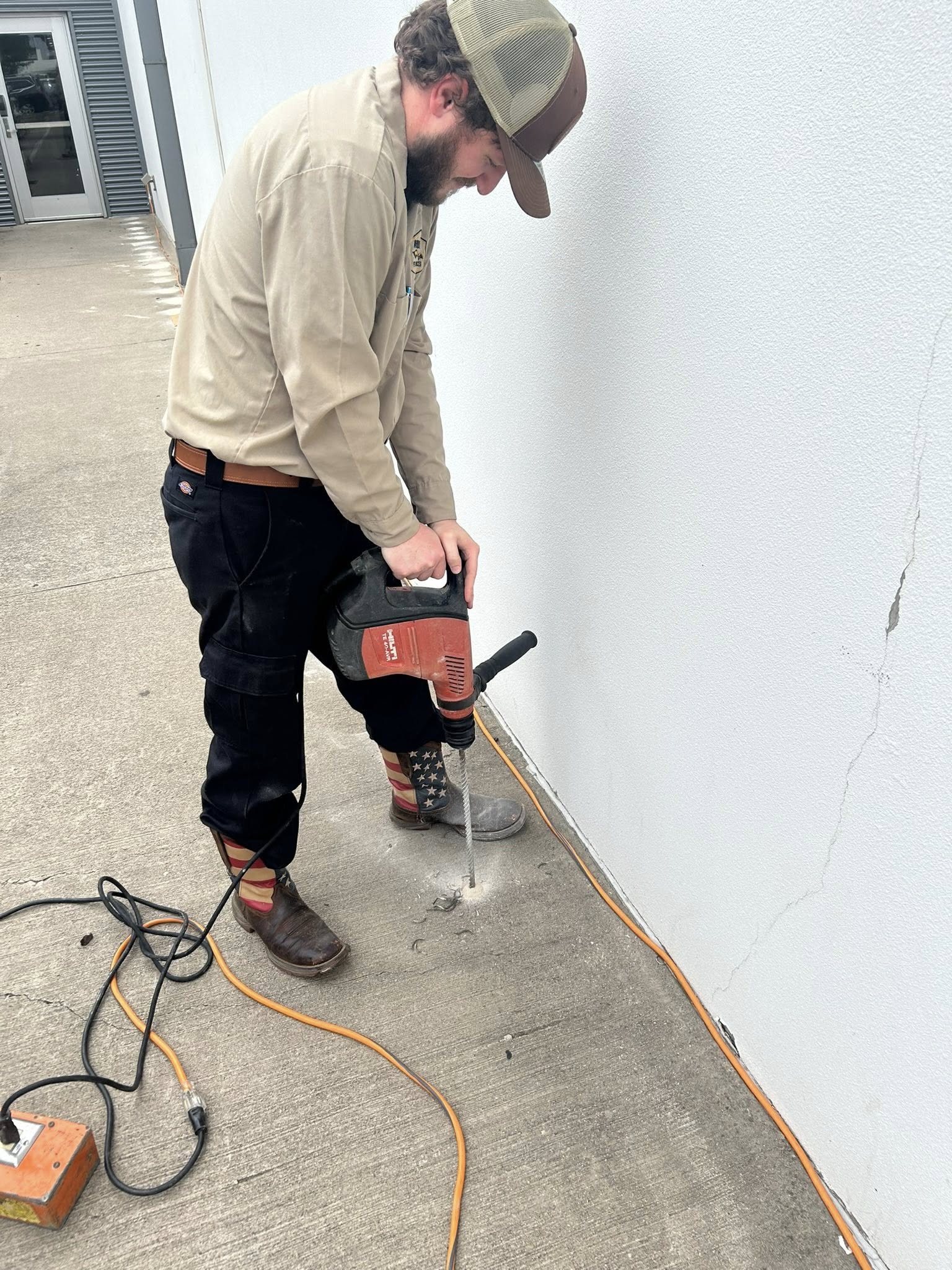 Technician drilling for soil treatment
